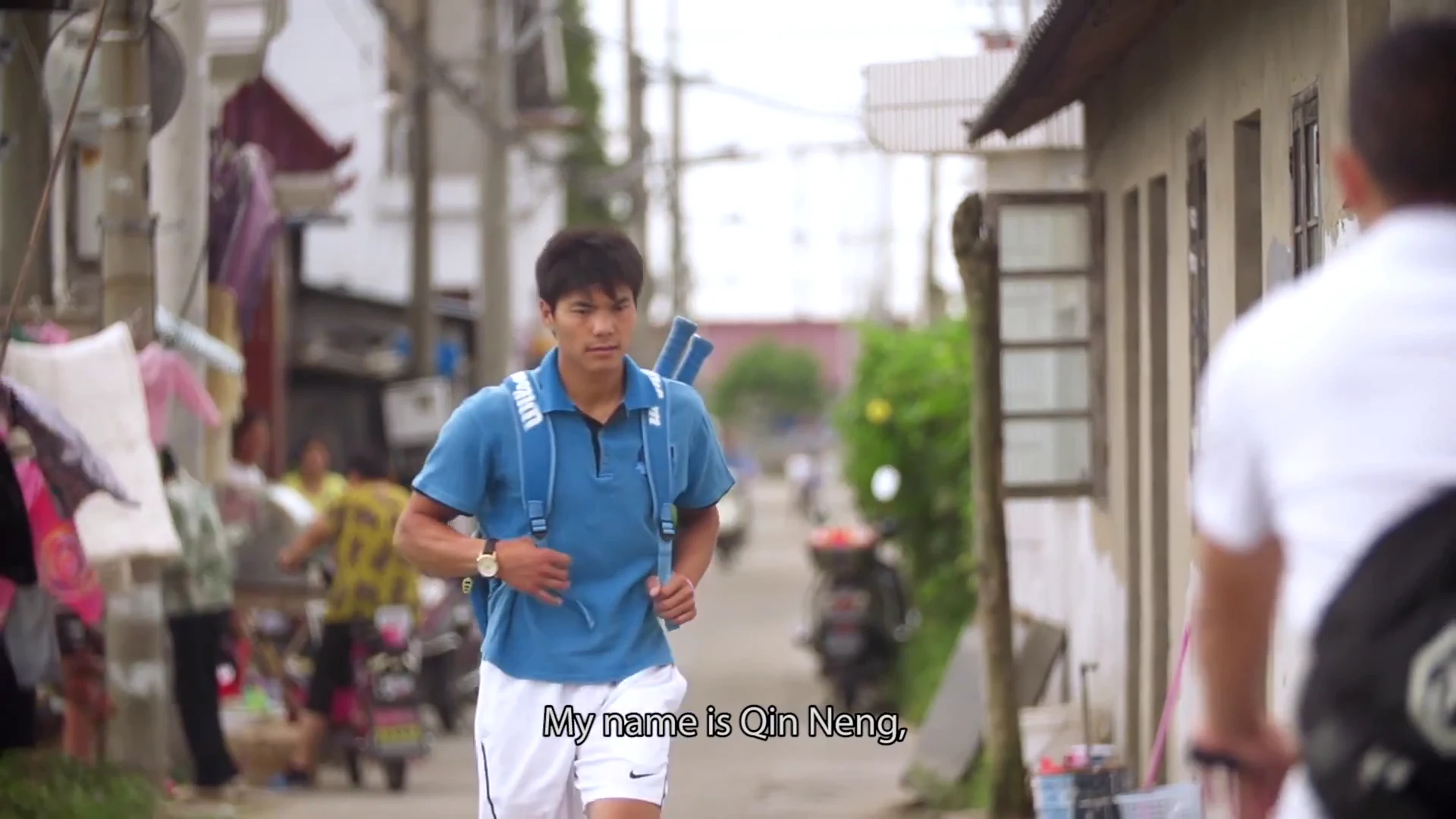 The coach arriving with a tennis bag over his shoulder.