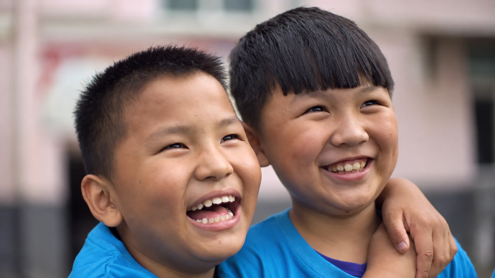 Two junior participants smiling together during the tennis session.