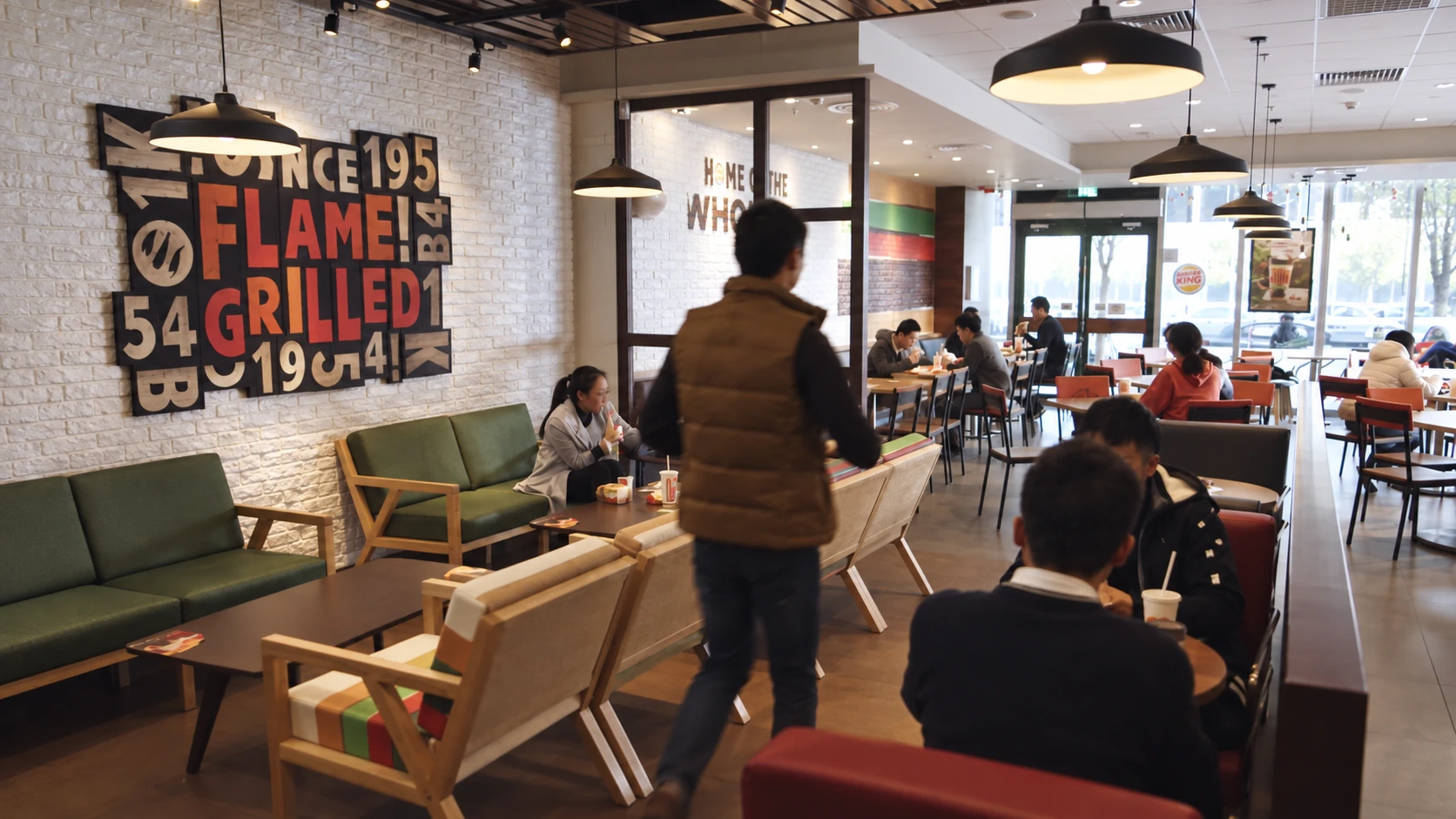 Customers, tables and seating inside a Burger King restaurant.
