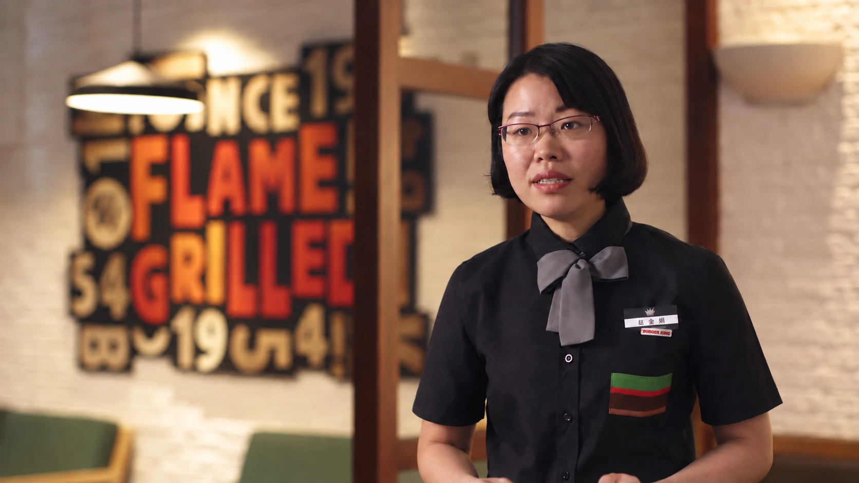 A Burger King team member speaking in a seated restaurant interview.