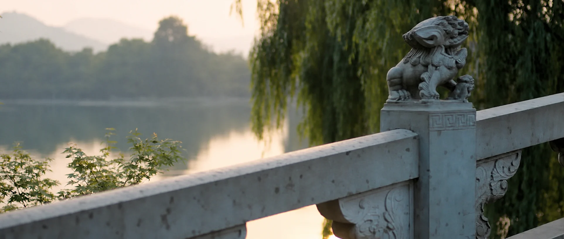 A stone bridge and lakeside greenery in Hangzhou.