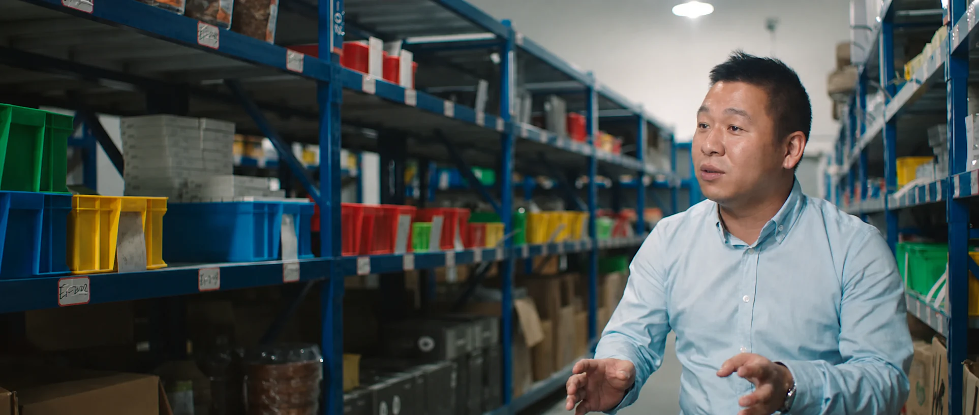 A man speaking inside a logistics facility.