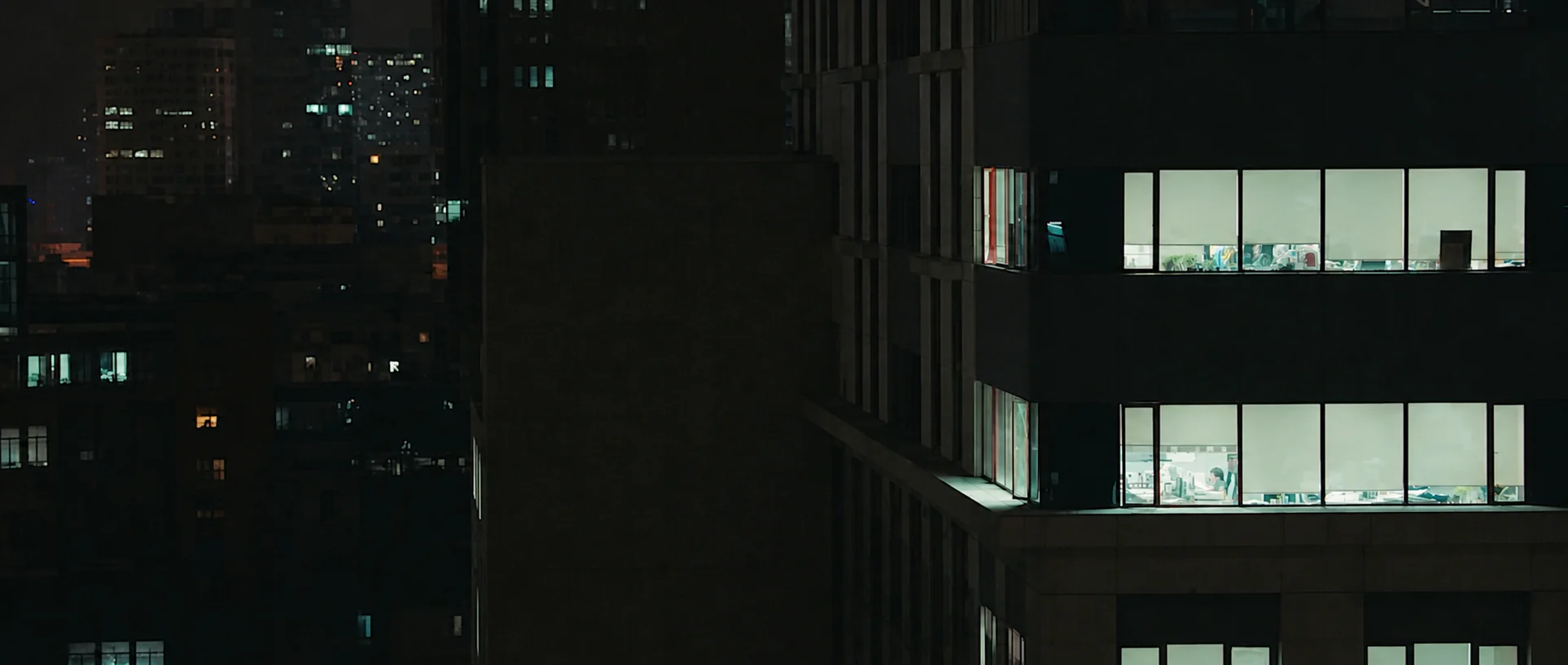 Lit office windows in a dark building at night.