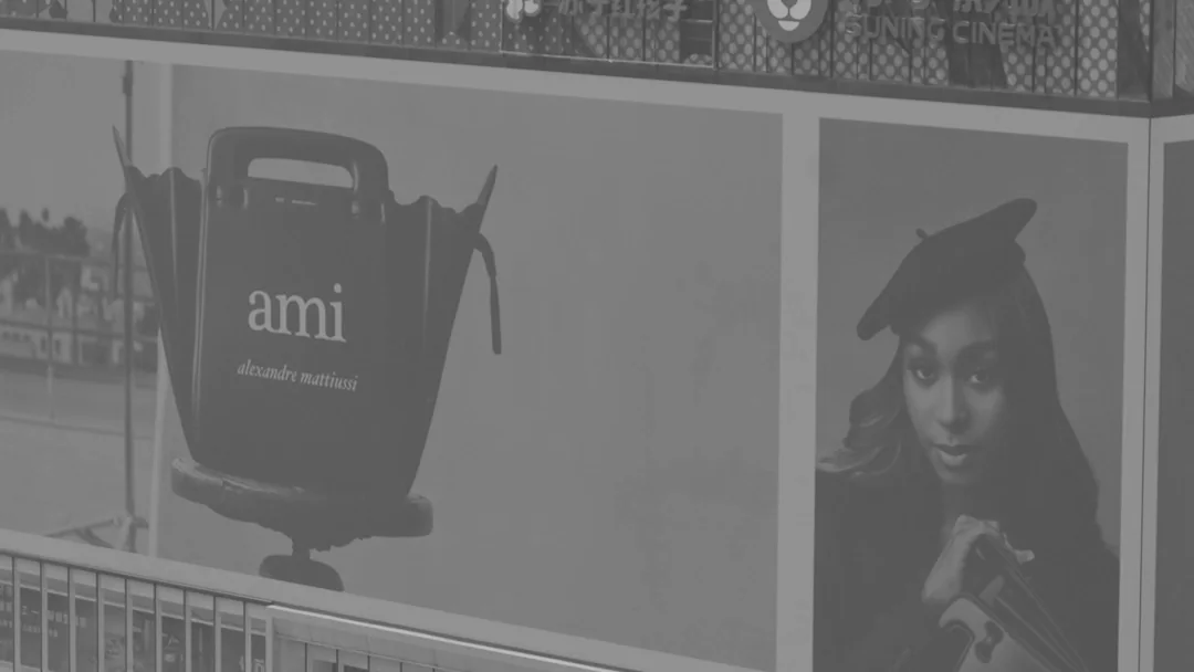 AMI Paris campaign imagery across a multi-panel urban façade in Chongqing.