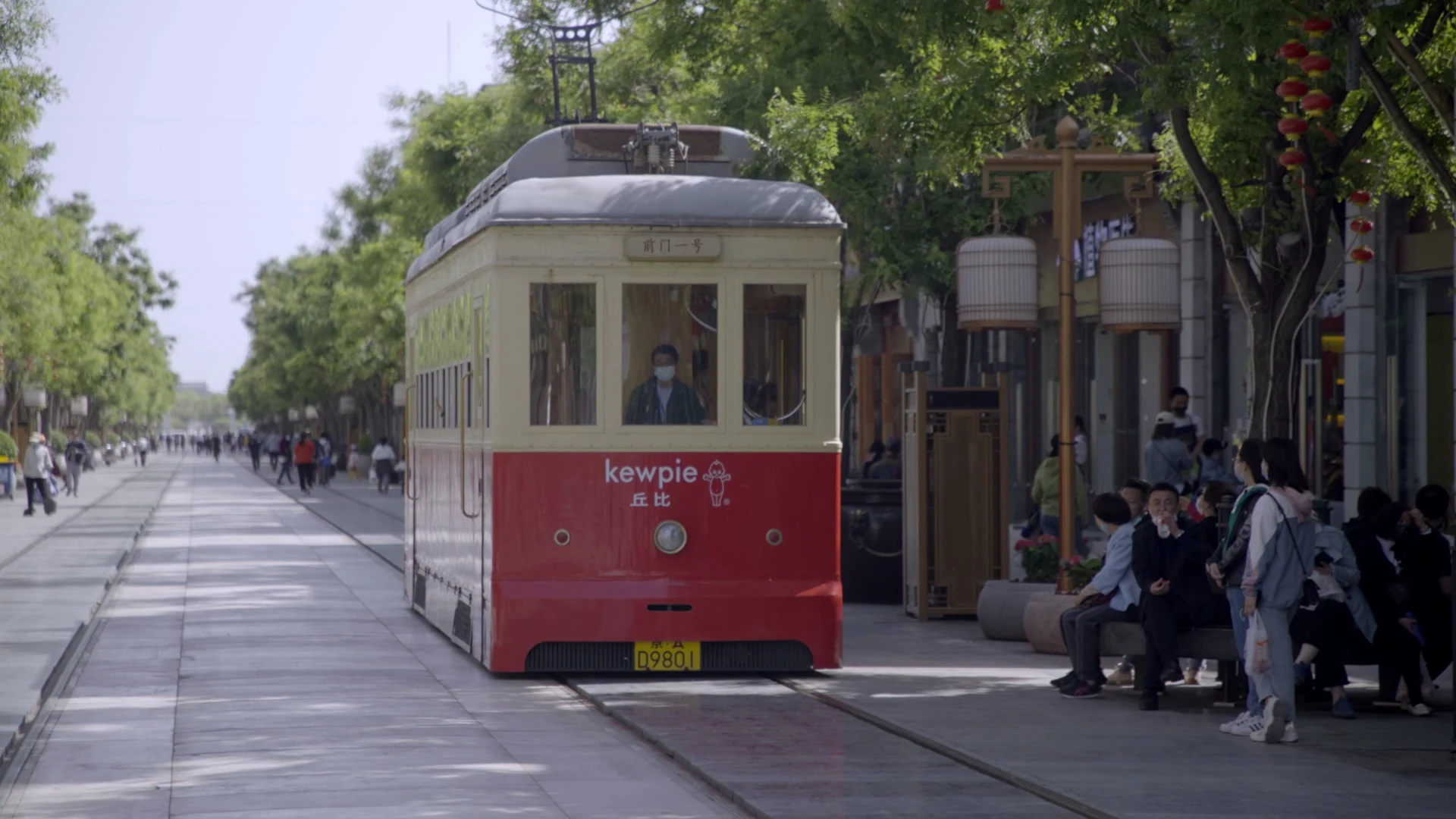 Tram on a tree-lined Beijing pedestrian street.