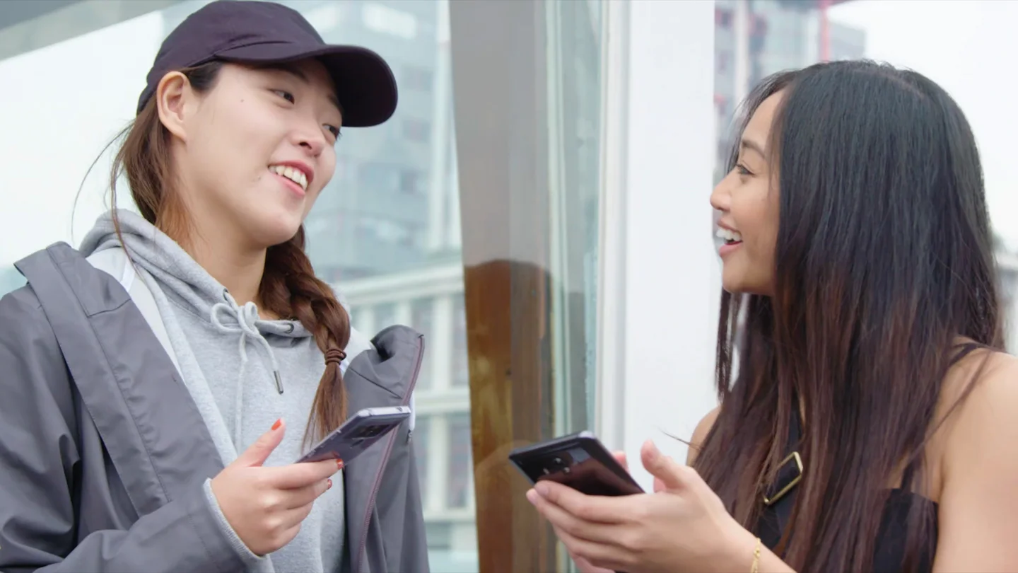 Two participants talking while holding smartphones