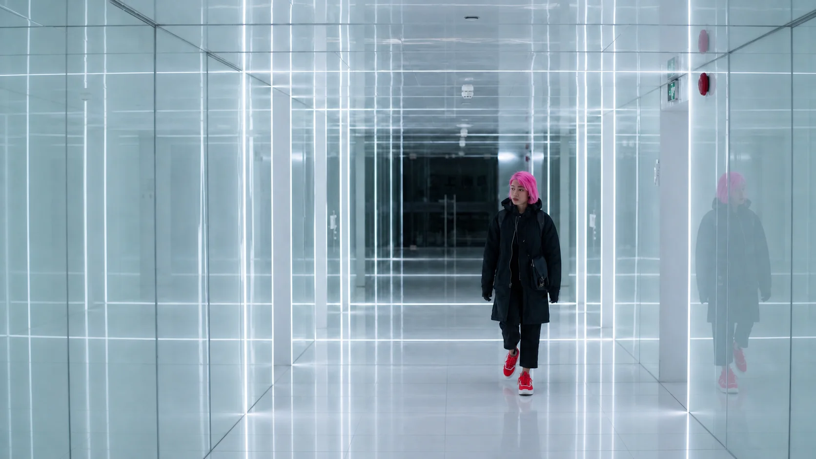 Jennifer Bin walking through an illuminated white corridor in Shanghai