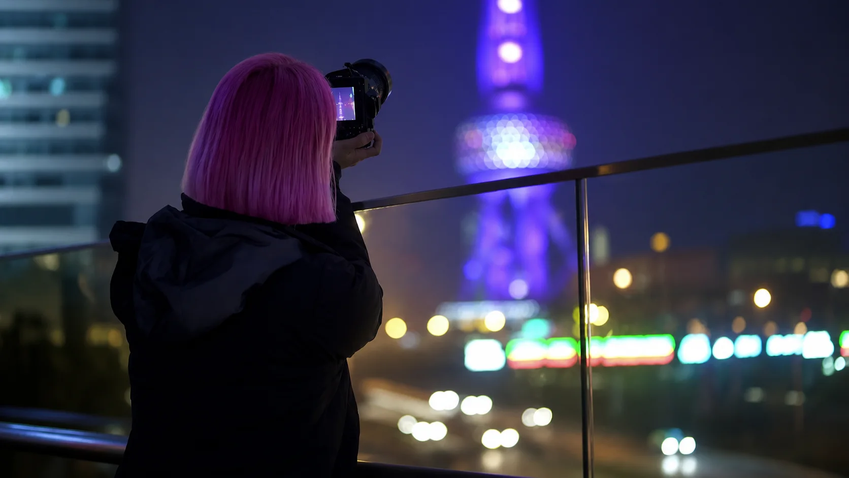 Jennifer Bin photographing the illuminated Oriental Pearl Tower at night