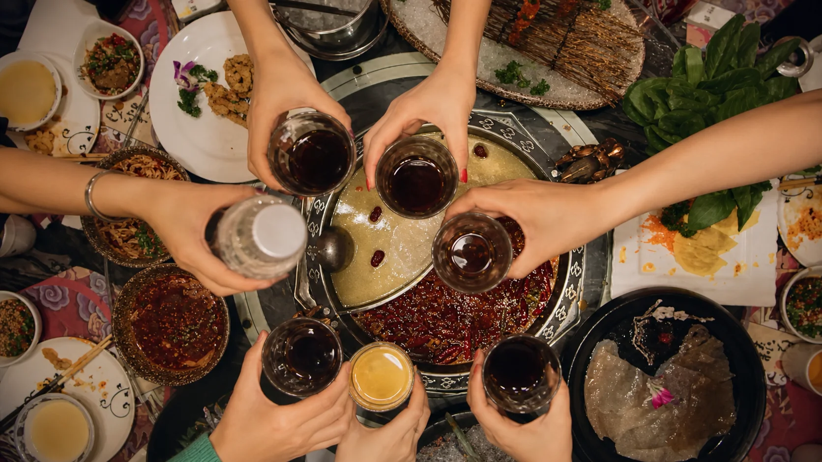 Members of One Crew raising drinks over a shared meal