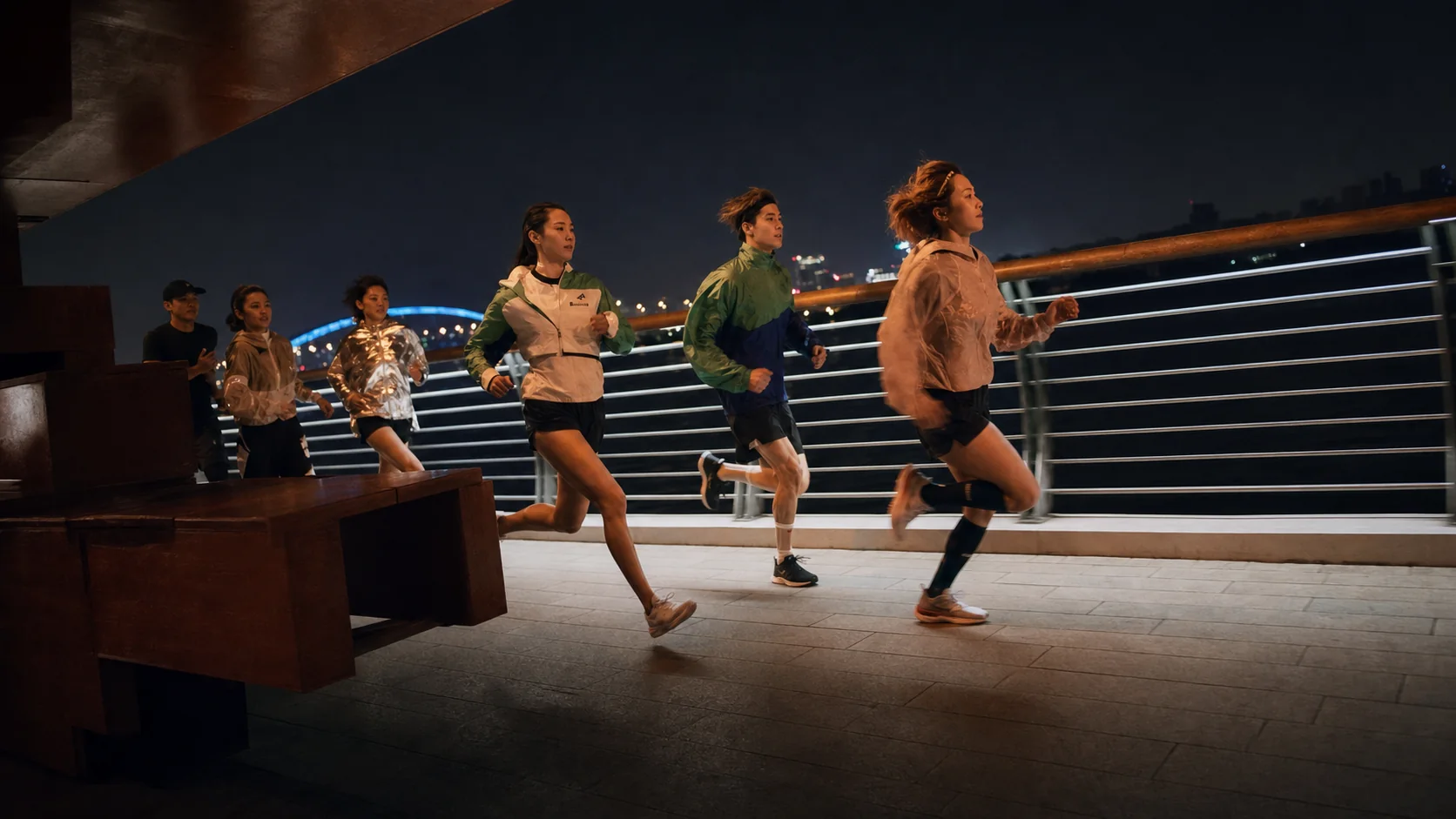 Members of One Crew running together across a bridge at night during filming