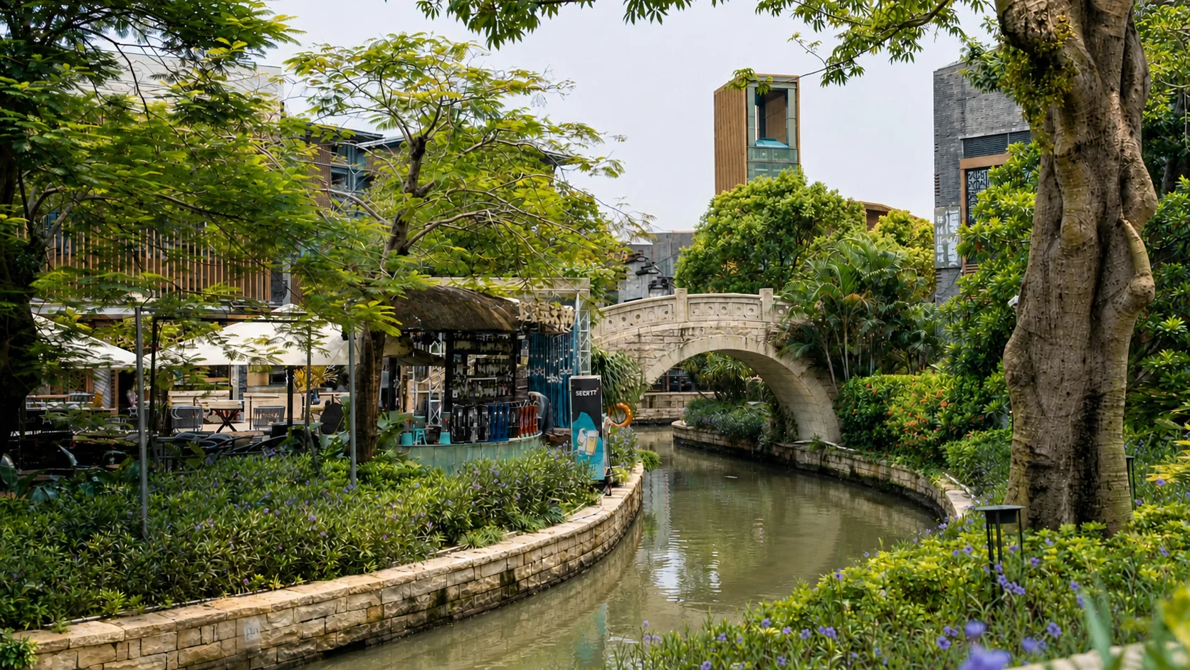 Landscaped canal path leading toward a small stone arch bridge near Suhe Creek