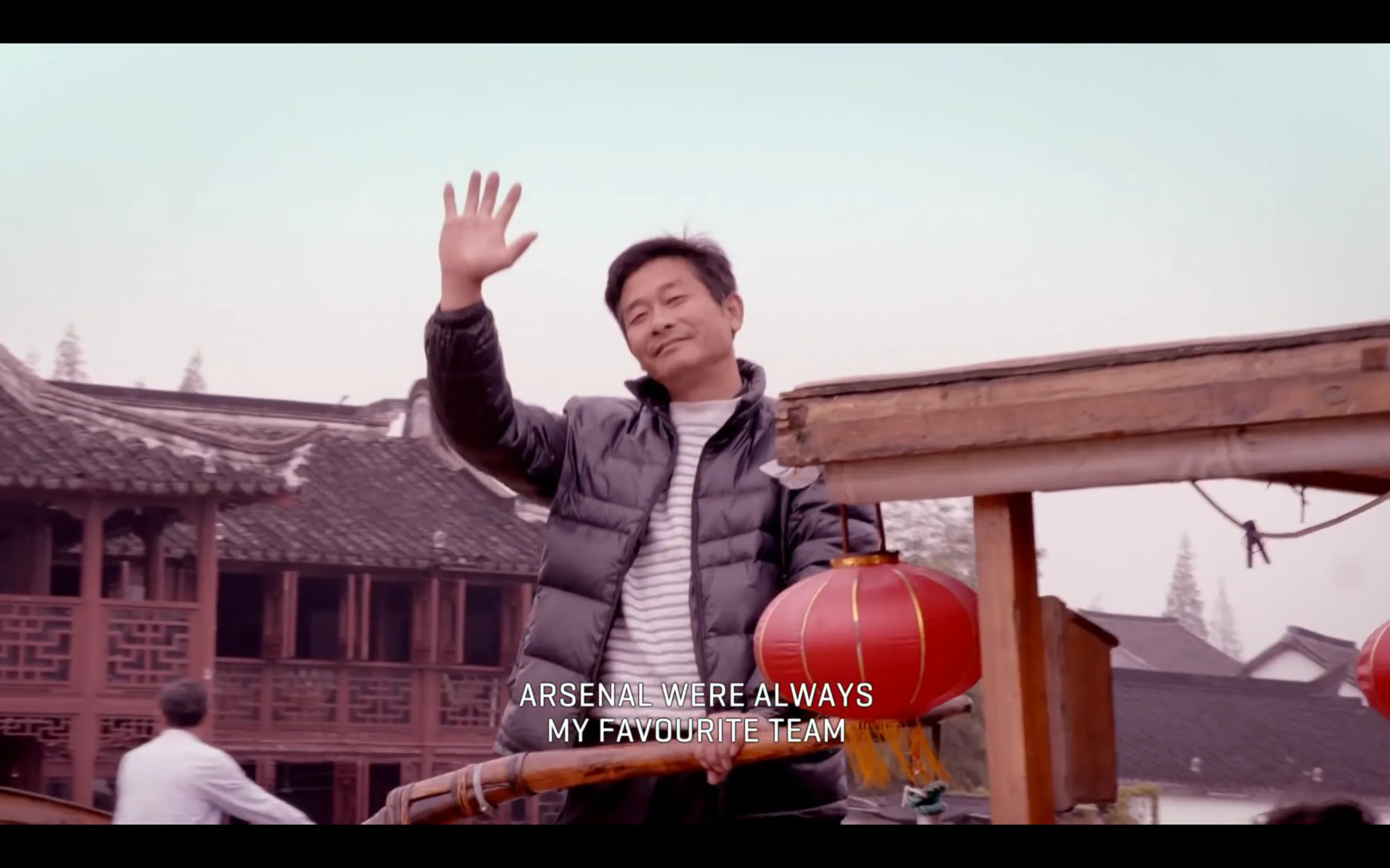 Shanghai Arsenal supporter waving from a boat beneath the subtitle Arsenal were always my favourite team