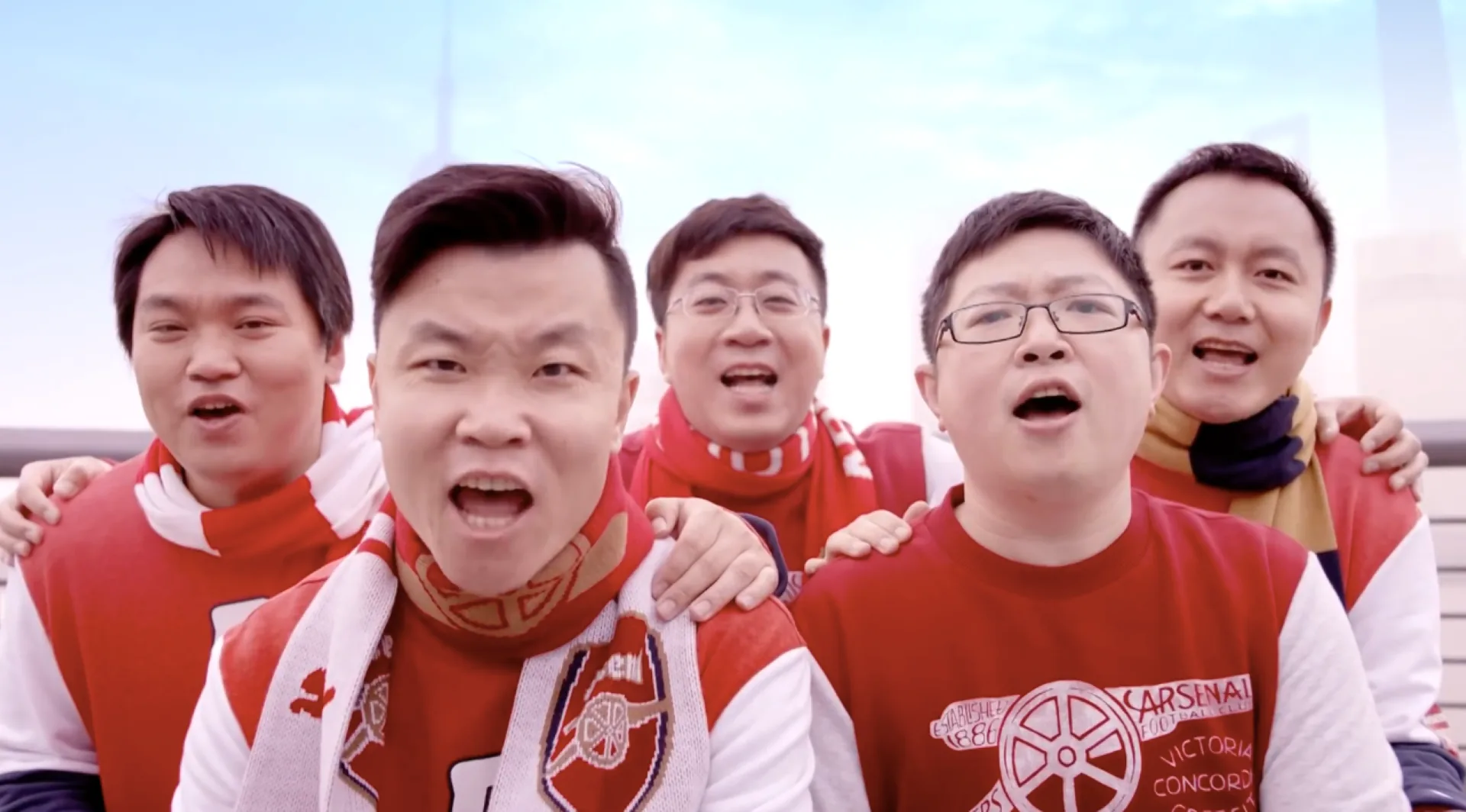 Five Shanghai Arsenal supporters chanting together in red fan clothing