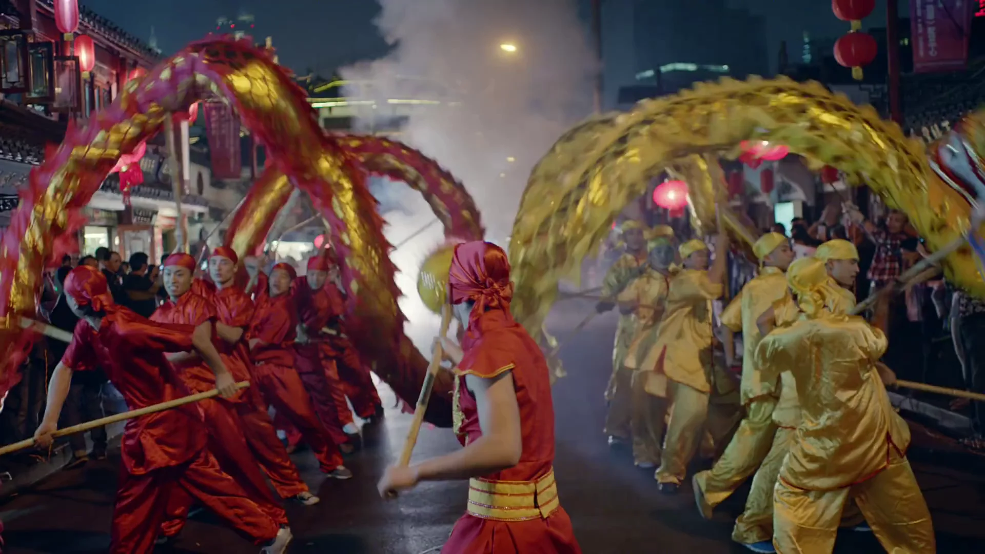 Red and gold dragon dancers performing in a Shanghai street at night
