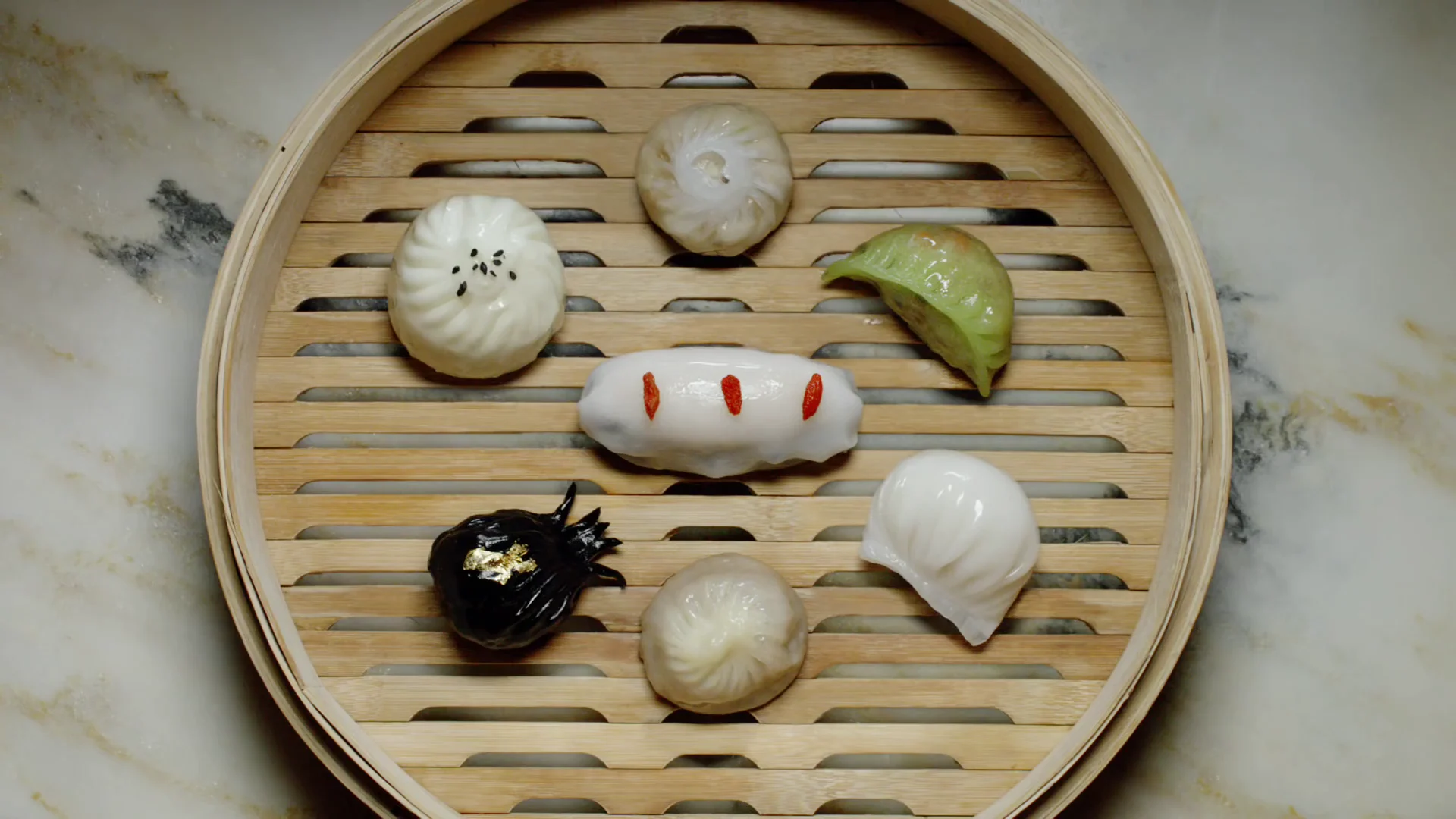 Selection of colorful dim sum arranged in a bamboo steamer