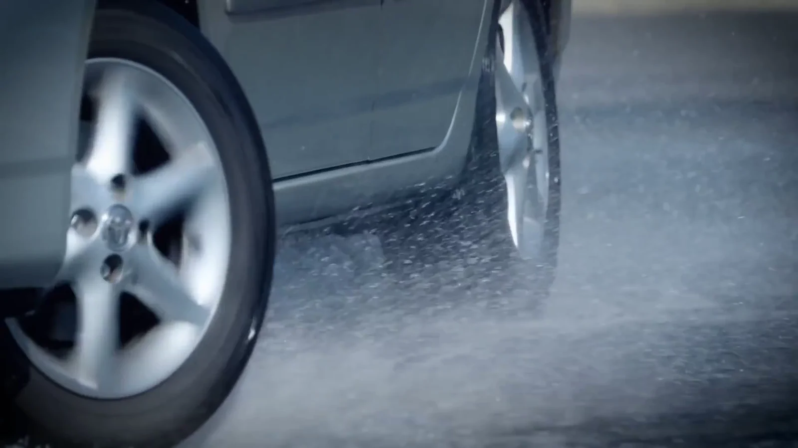 Close-up of vehicle wheels during a wet-surface braking test