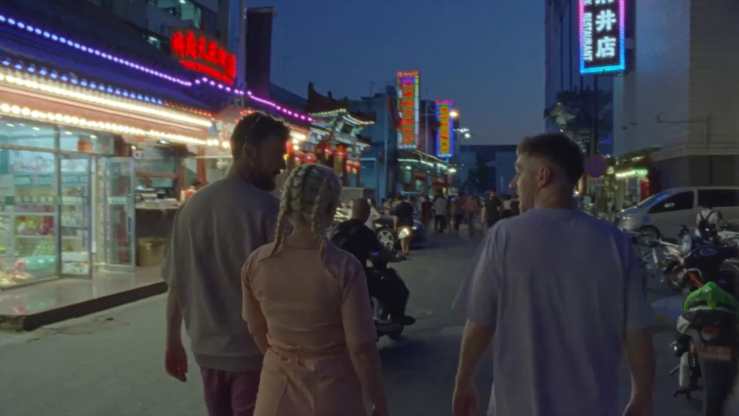 Clean Bandit walk through a Beijing street at night
