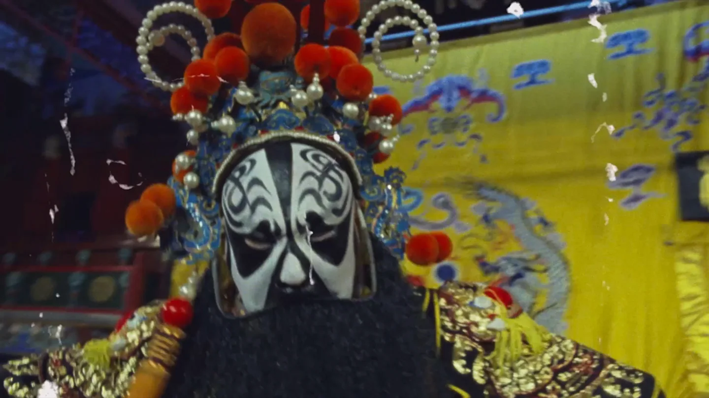 A Beijing opera performer in an ornate headdress and painted mask