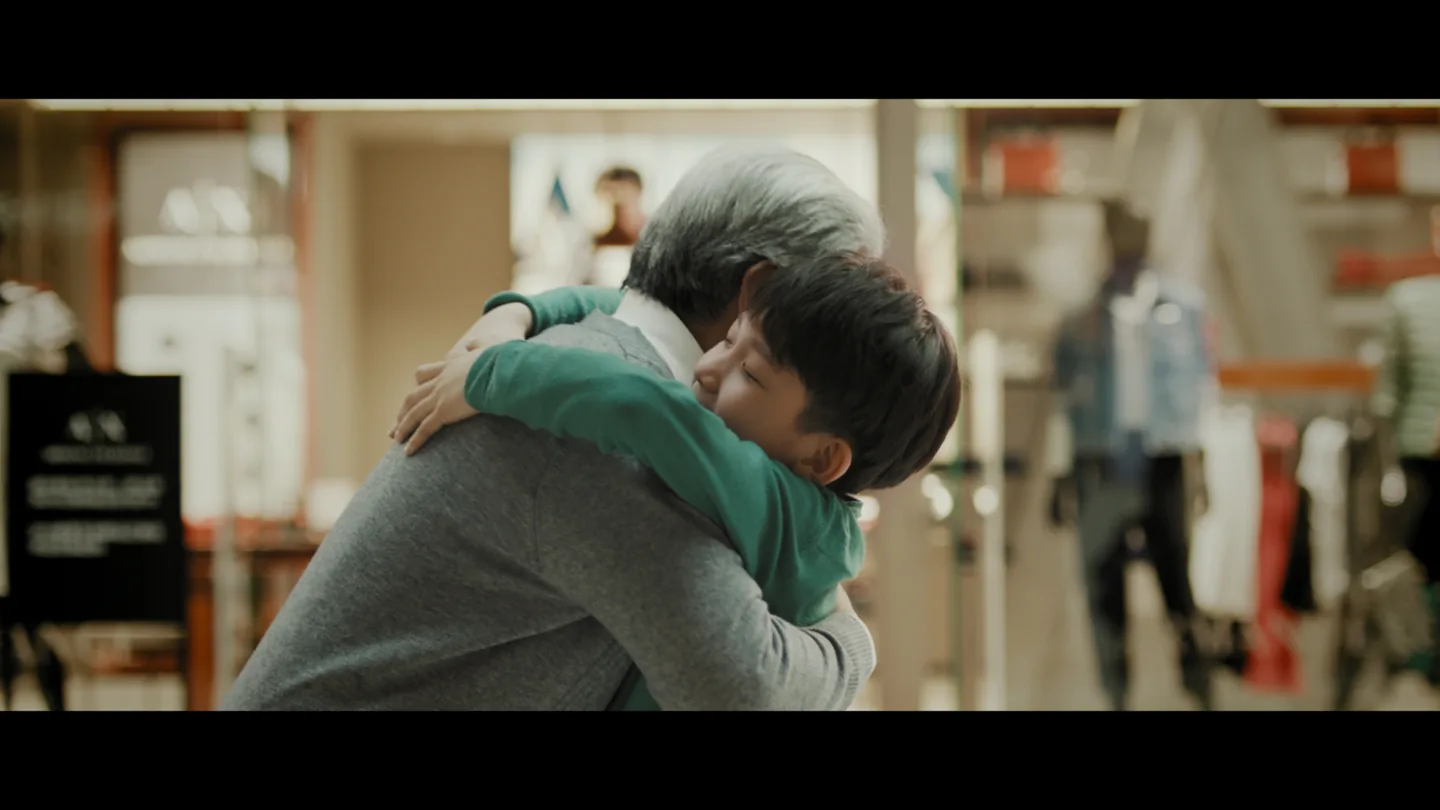 Boy hugging his grandfather inside the mall