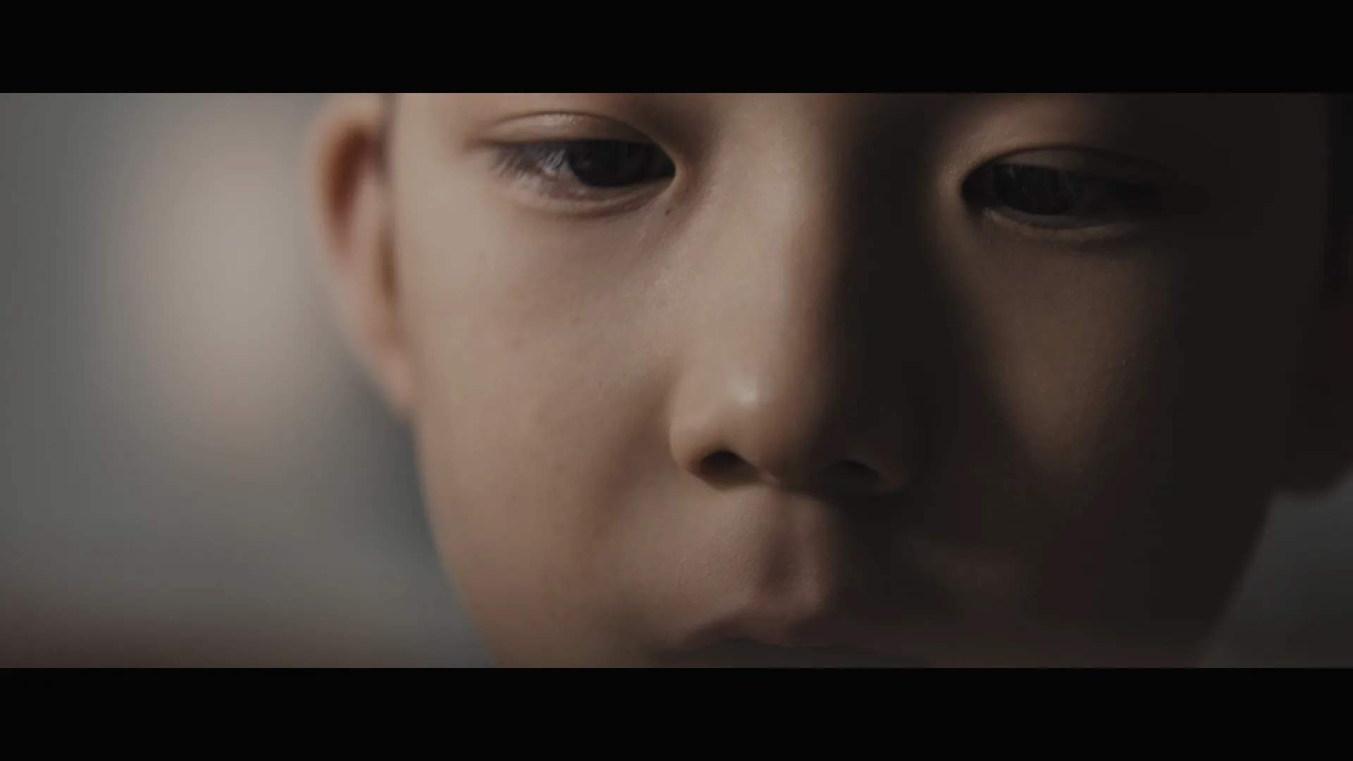 Close portrait of the boy looking down during the family story