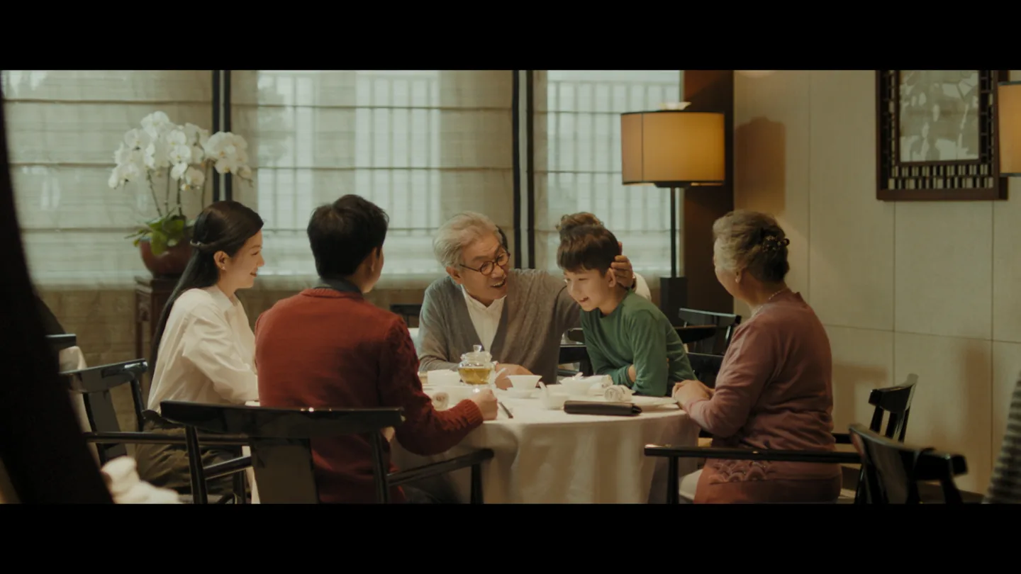 Parents, grandparents and the boy gathered around a restaurant table