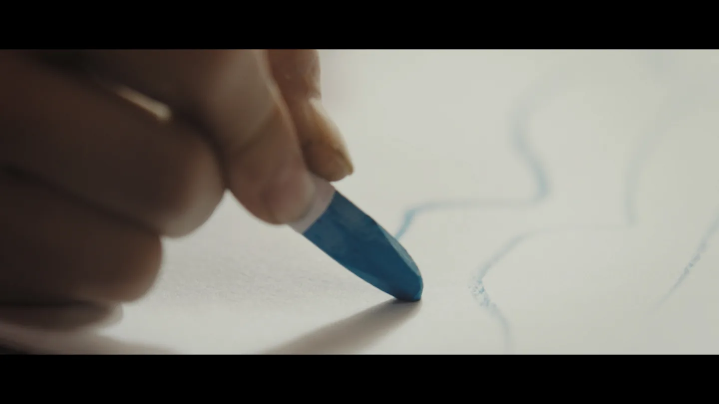 Blue crayon drawing being added to the architect's sketchbook