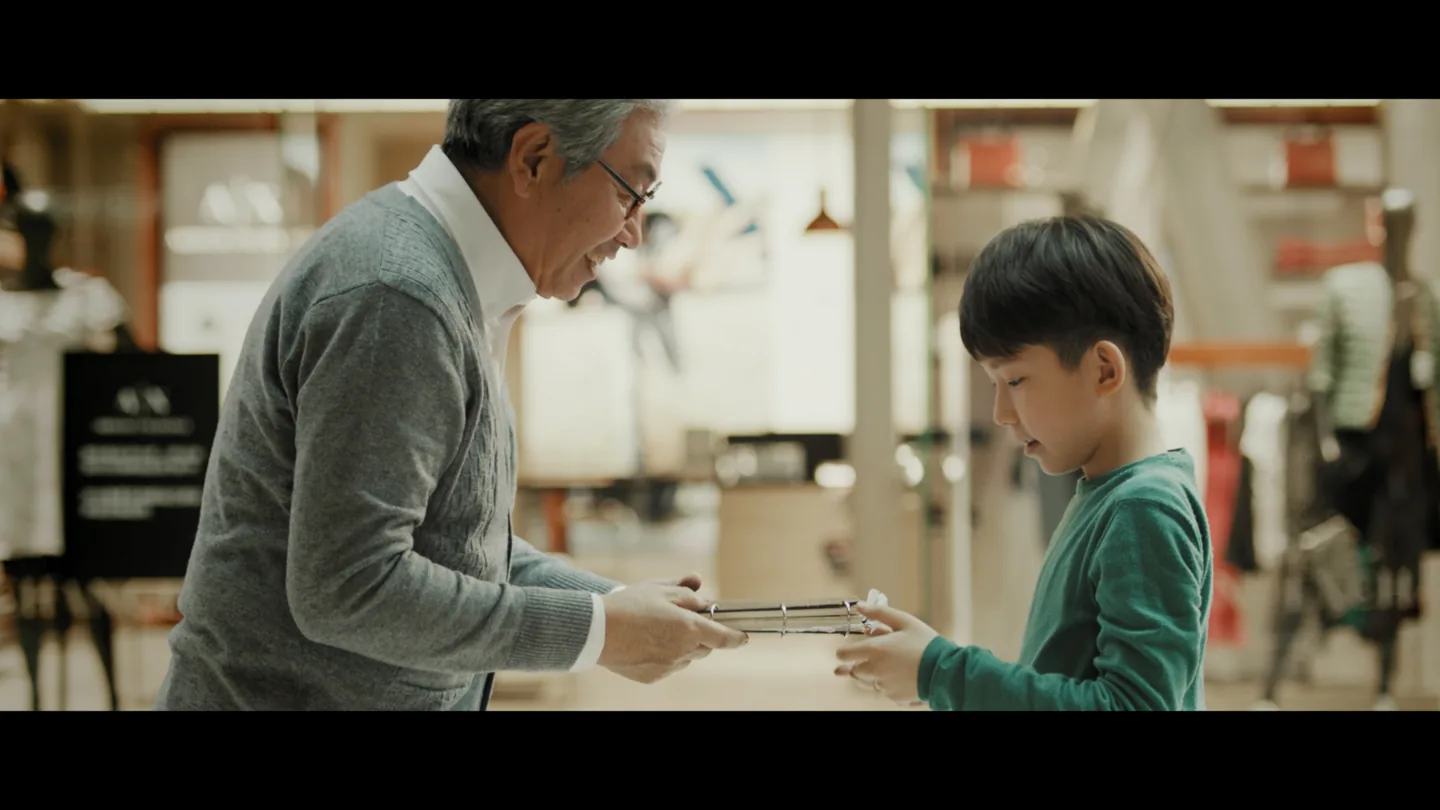 Grandfather passing his architectural sketchbook to his grandson