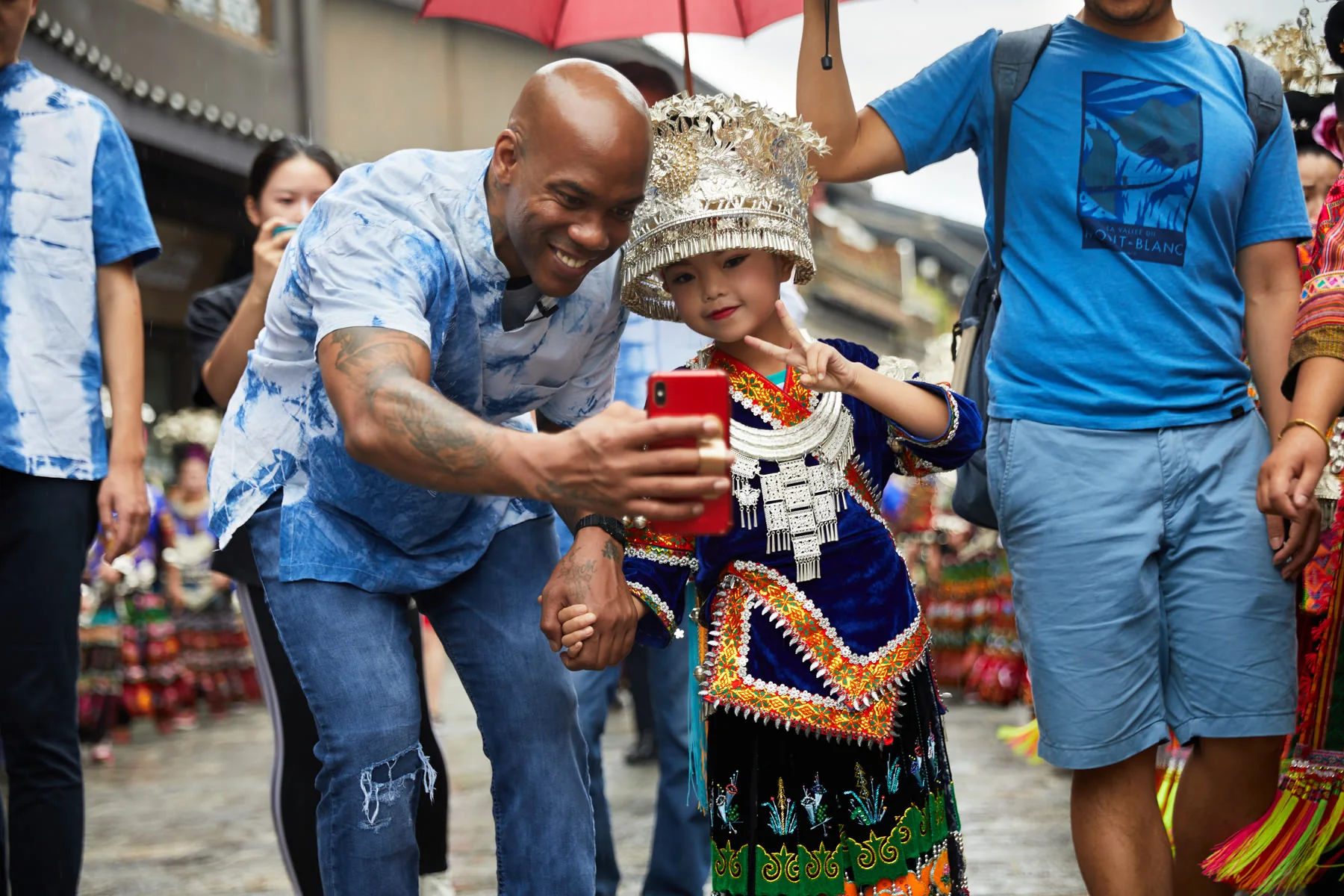 An adult participant takes a selfie with a child in traditional Danzhai clothing