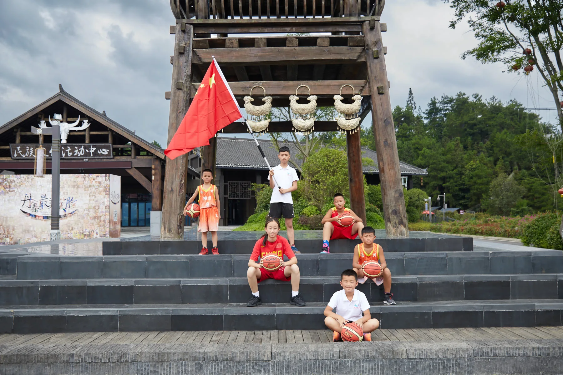 Young basketball players gather beside a Danzhai village landmark