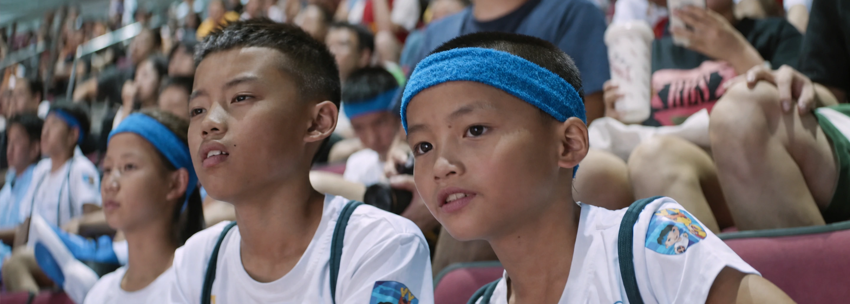 Young participants watch the Beijing basketball event from arena seating
