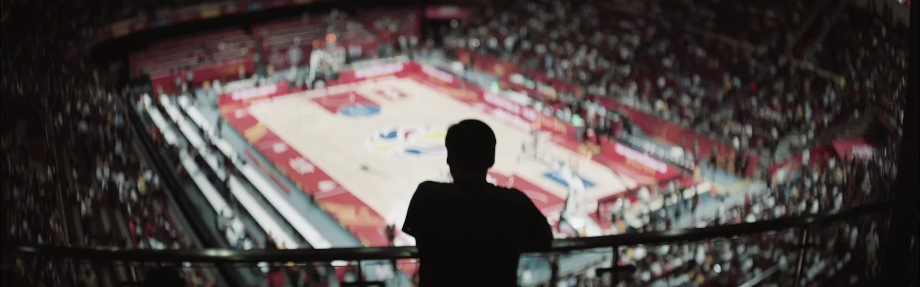 A participant looks over the Beijing basketball arena from an upper concourse