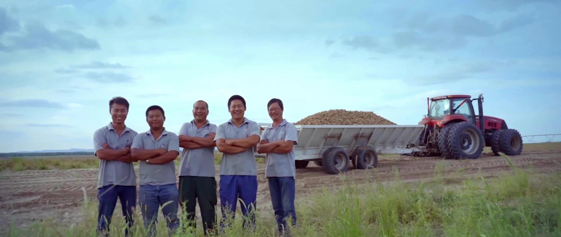 Five people standing beside farm machinery in Inner Mongolia.
