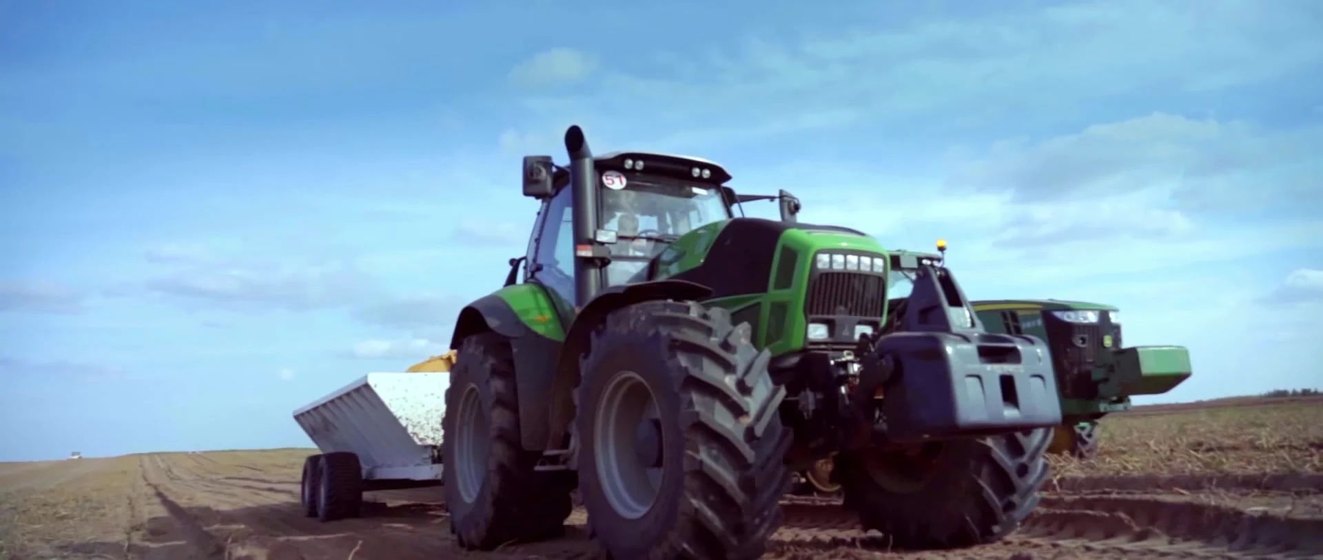 A green tractor working in an Inner Mongolia potato field.