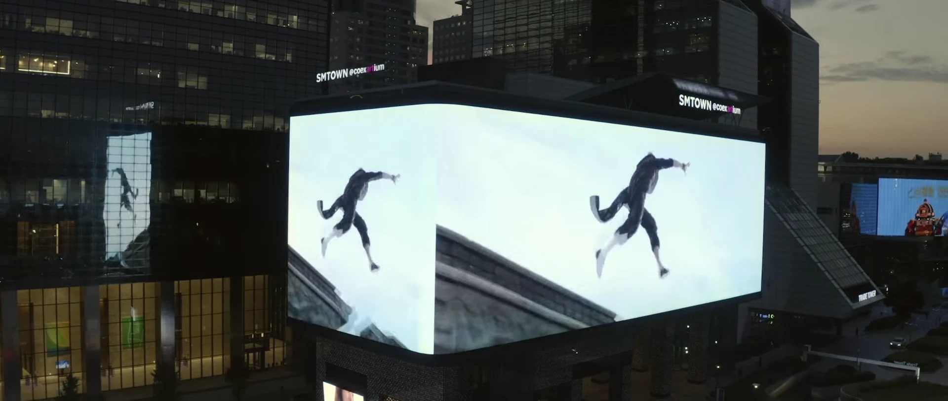 Moving fashion imagery spans two adjoining screen faces around a corner.