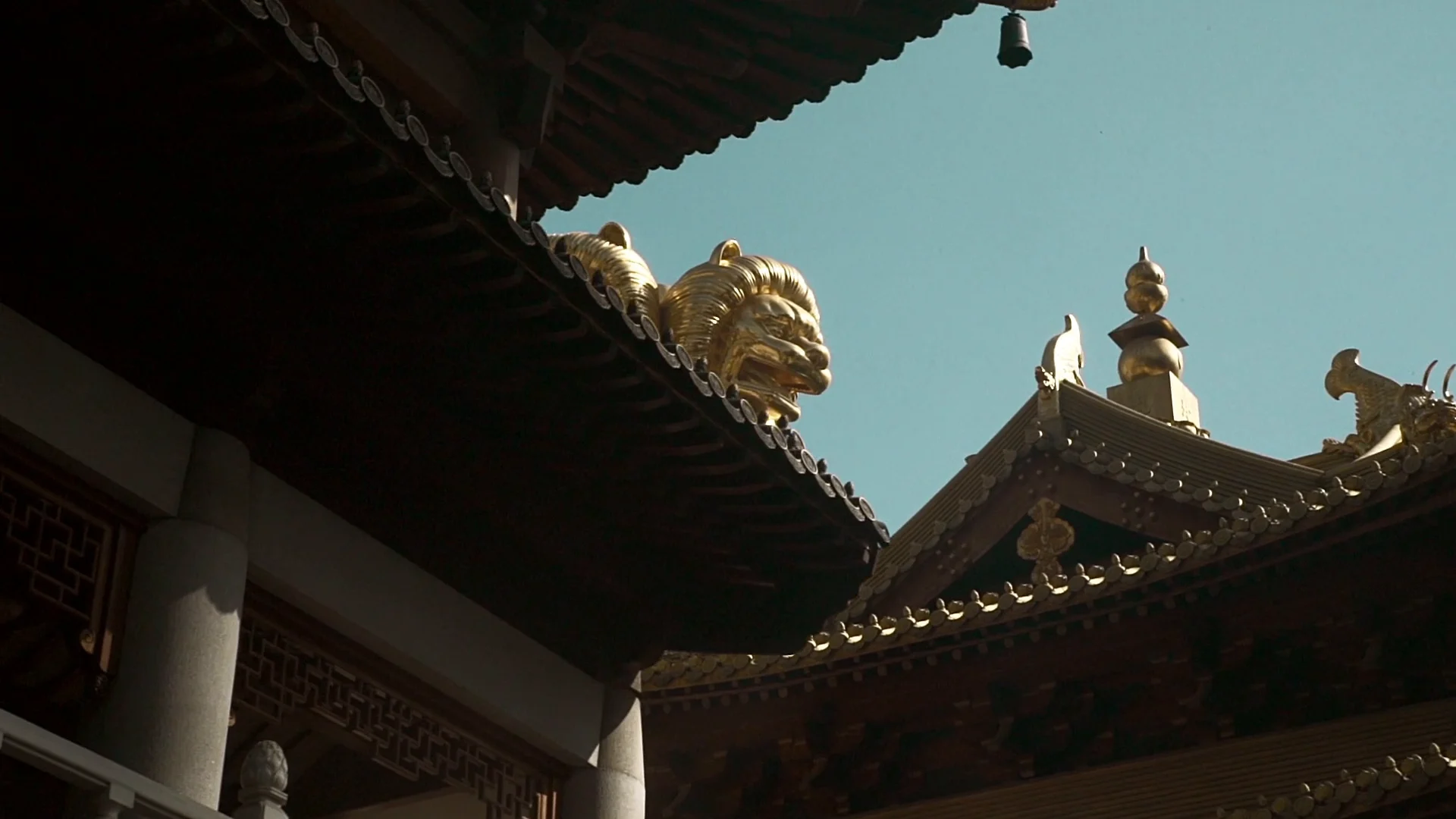 Golden figures and traditional temple architecture in Shanghai.