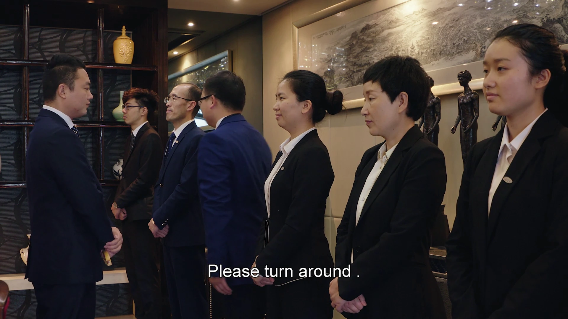 A group receiving instructions, with English subtitles in the film. Frame from Ascension.