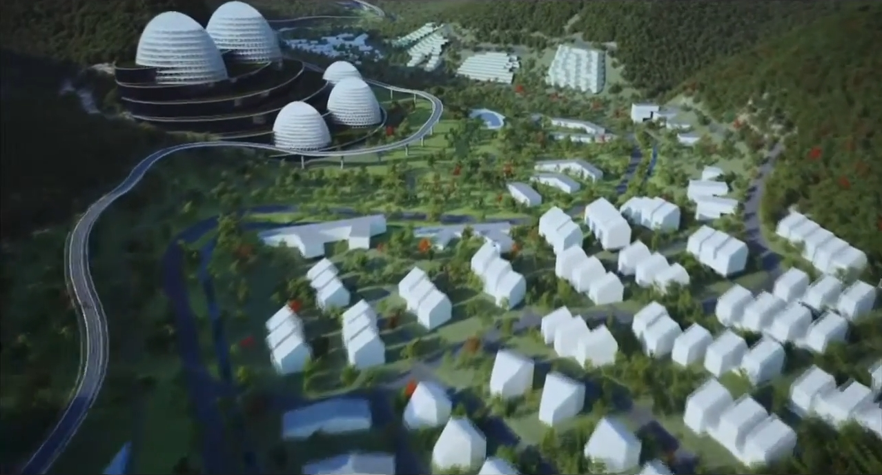 A model of a proposed development in a green valley. Film still.