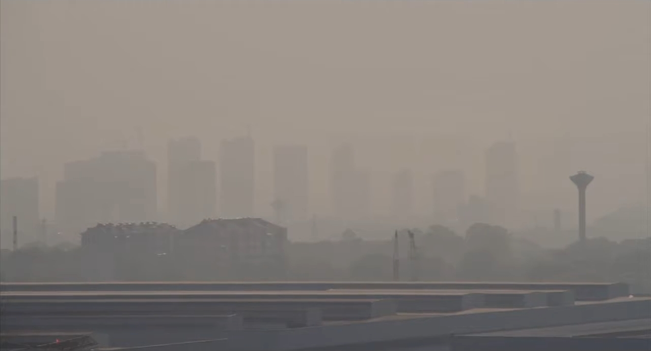 A city skyline seen through haze. Film still from Ecopolis China.