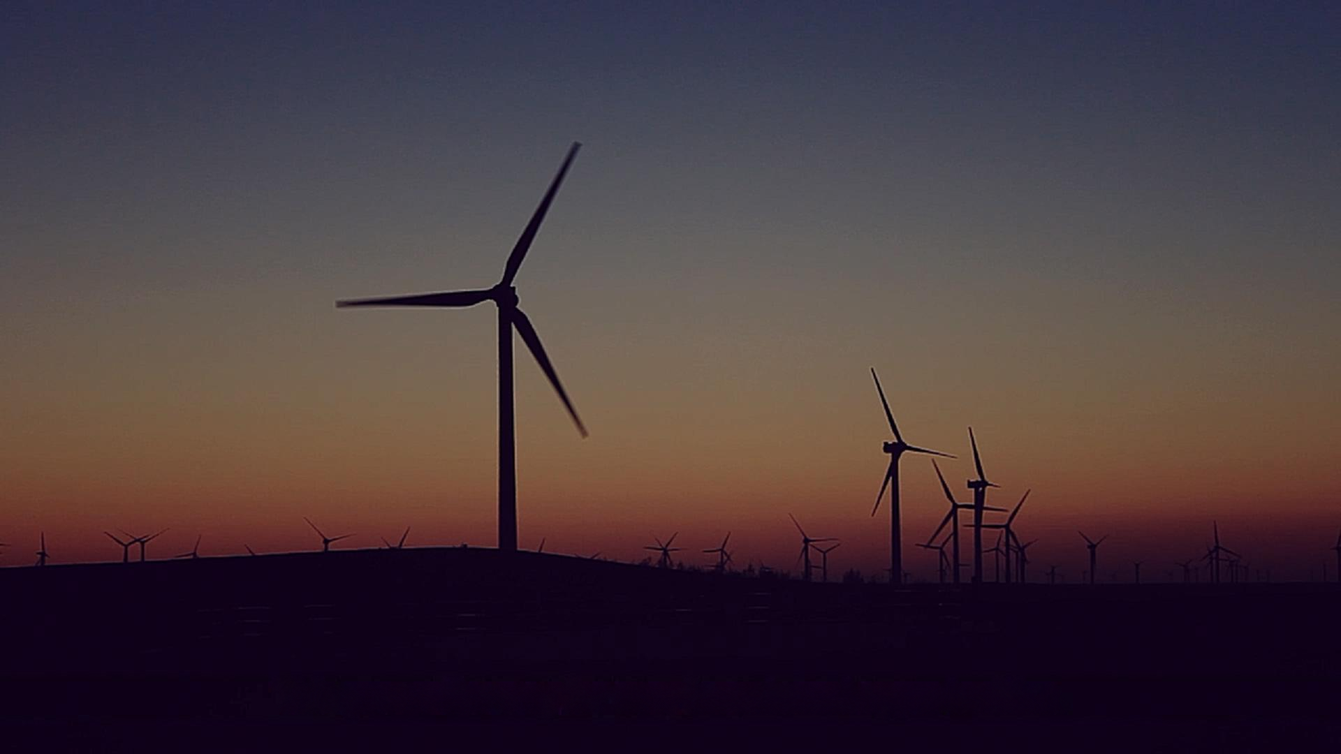 Wind turbines against an evening sky. Film still.