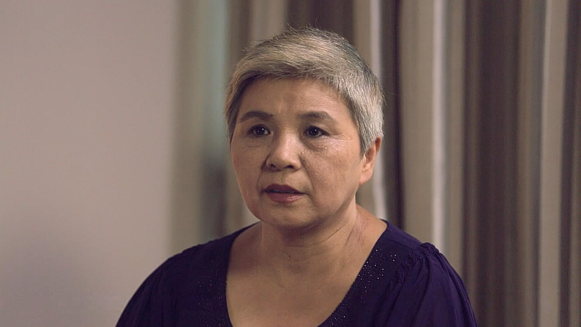 A contributor interviewed at home. Film still.