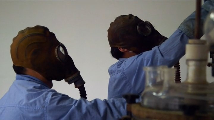 Protective masks in a workshop scene. Episode still.