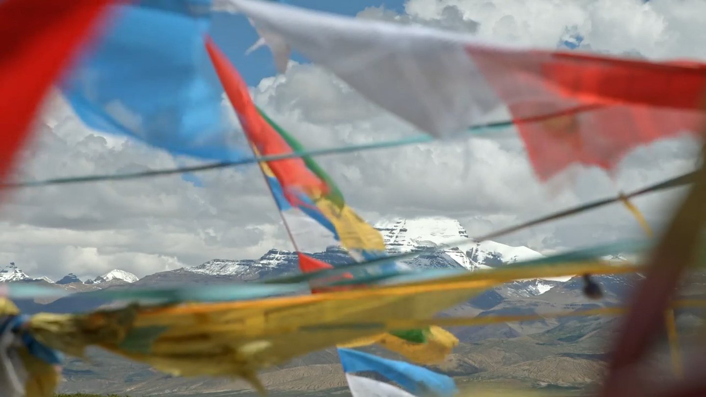 Flags in the foreground of a mountain view. Programme still.