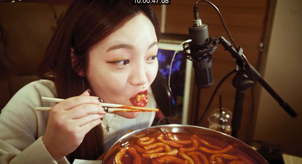 eating spicy korean rice cake during the show