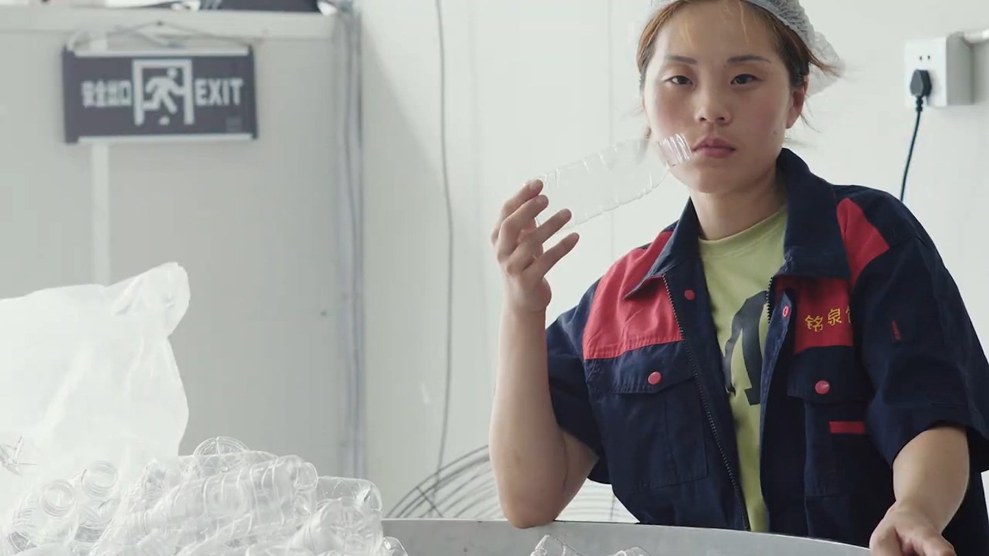 A worker with a clear plastic container. Frame from the Ascension trailer.