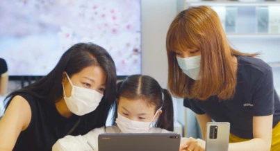 two adult and a kid using ipad