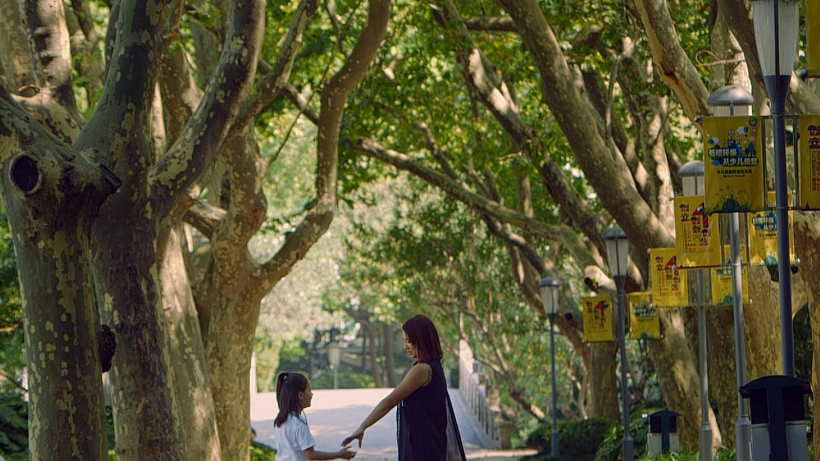 A mother and daughter beneath the trees. Film still.