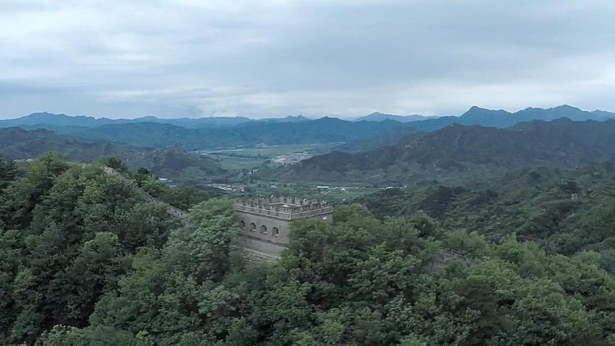 The Great Wall winding through green hills. Film still.