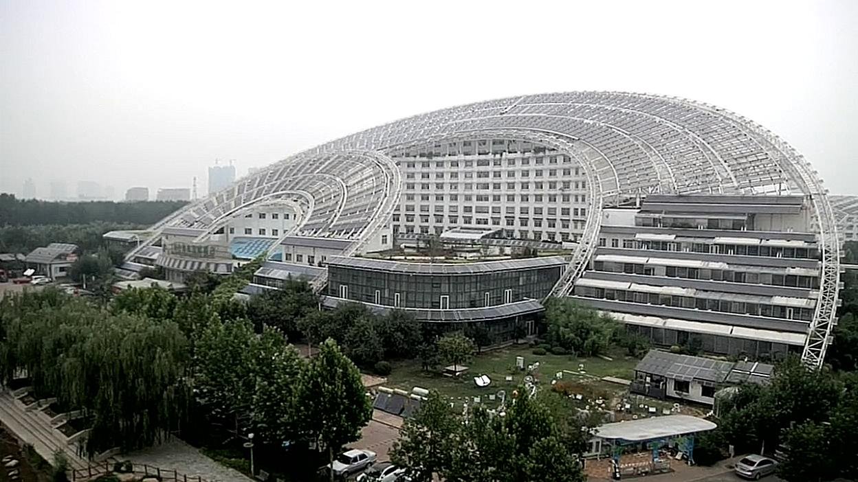 Another view of the curved building and its grounds. Film still.