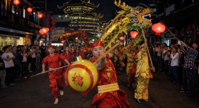 Chinese dragon dance performance at night with red lanterns, traditional performers, and golden dragon in a crowded street, captured in cinematic film style