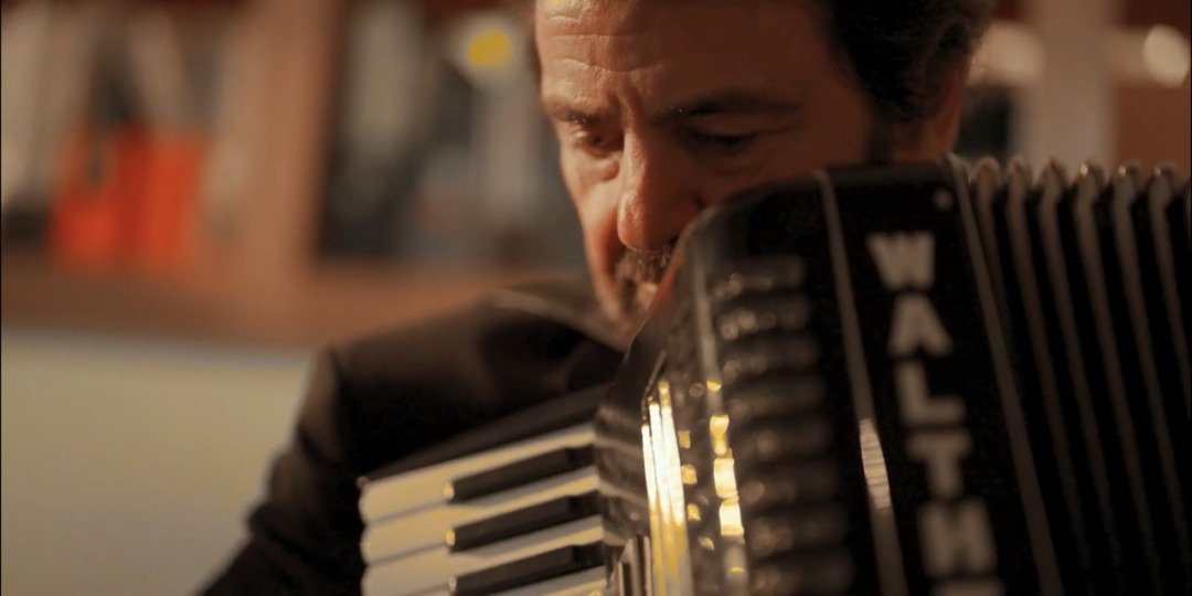 Close-up of an artist playing accordion, captured during a behind-the-scenes moment on a documentary-style video production in China.